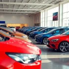 Buy a car in a vibrant showroom filled with new and used vehicles, showcasing an inviting scene.